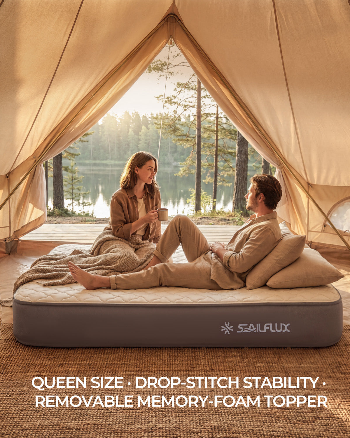 Couple relaxing on the Voyage CloudTop queen air mattress inside a canvas bell tent beside a lake at sunrise